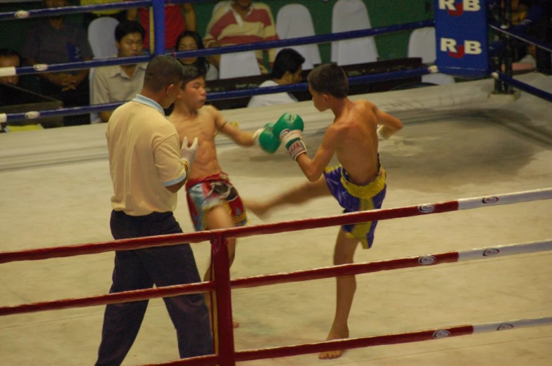 a couple of young men standing next to each other on top of a boxing ring