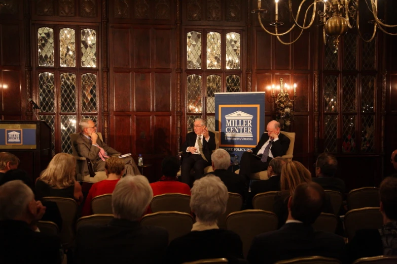 two men on stage talking to a group of people