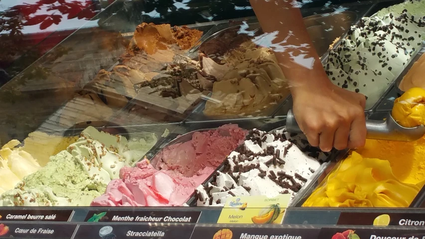 a man scooping ice cream from a metal spoon