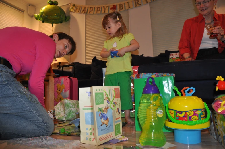 a woman and a little girl putting presents into a present