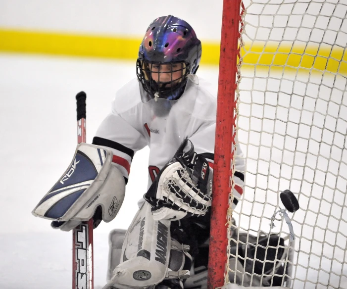 a young hockey player stops at the goal during a game