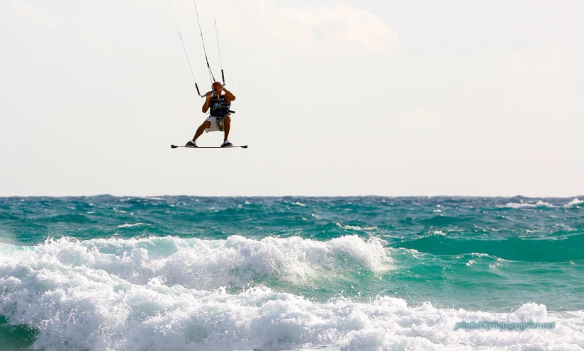 a man riding a wakeboard while being pulled by a kite