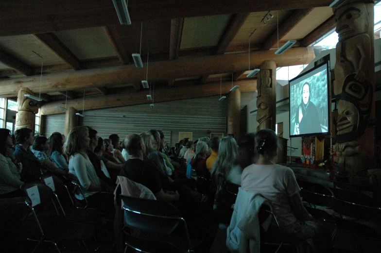 people watch a presentation on the screen in a building