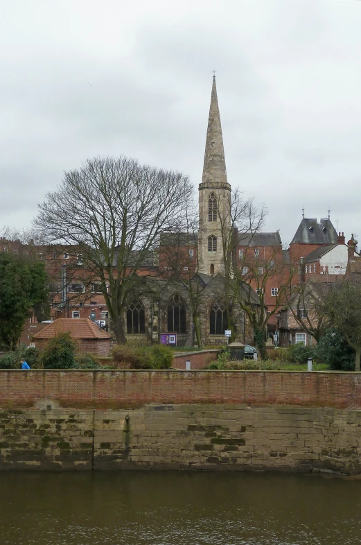 a river is passing by a town with an old church