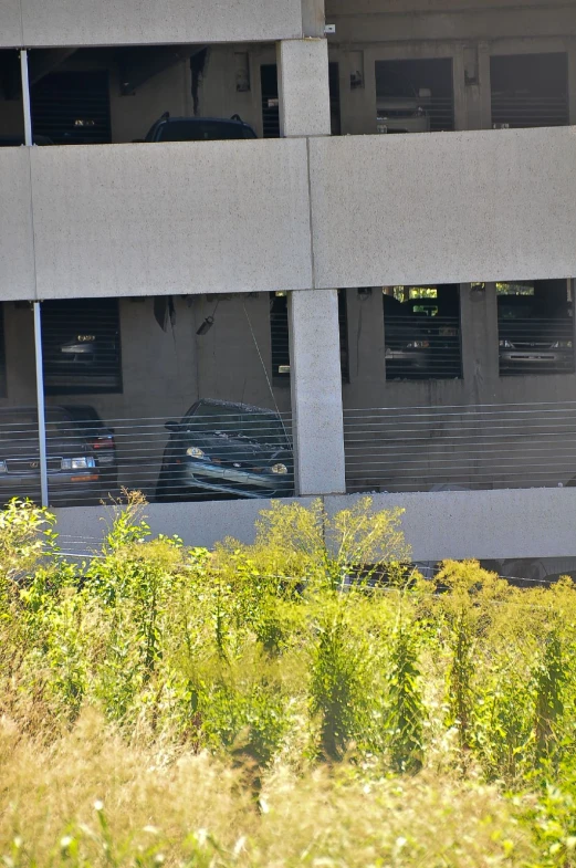 a building that has been demolished in half with grass and bushes around it