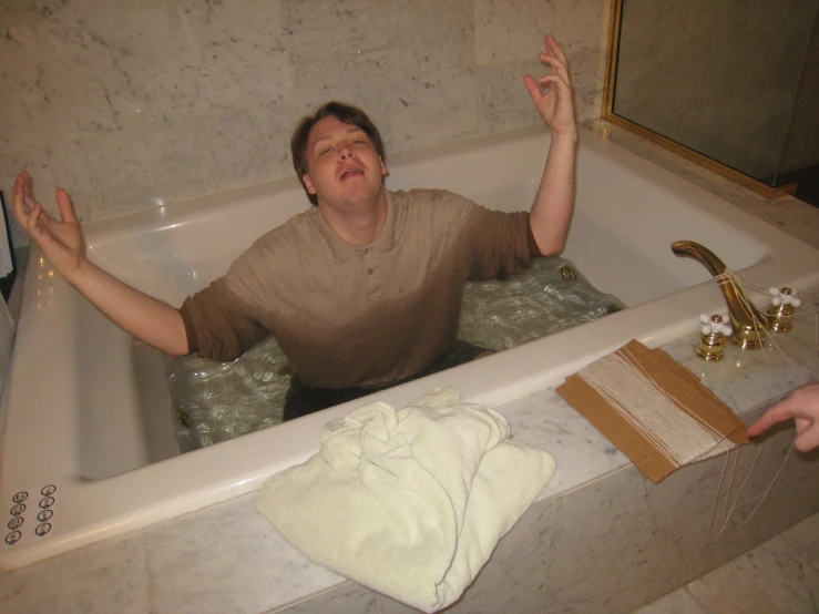 the man sits in the bathtub with his hands wide open