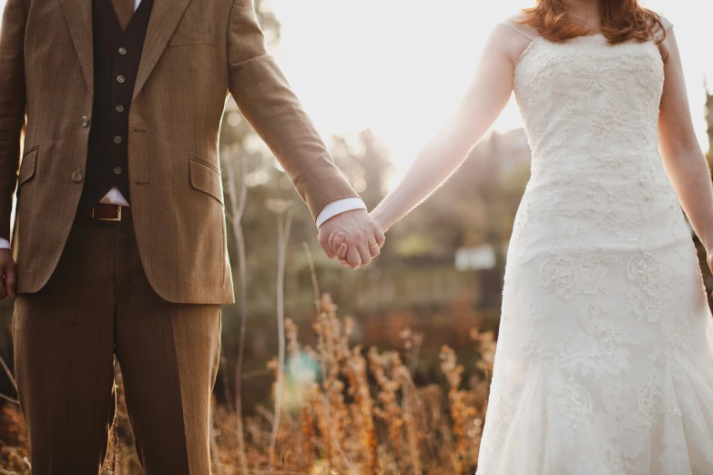 the newly married couple are walking holding hands