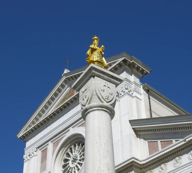 a tall clock tower with gold statues on top