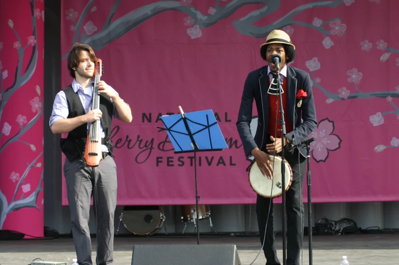 two men are on stage, one of whom is playing a musical instrument