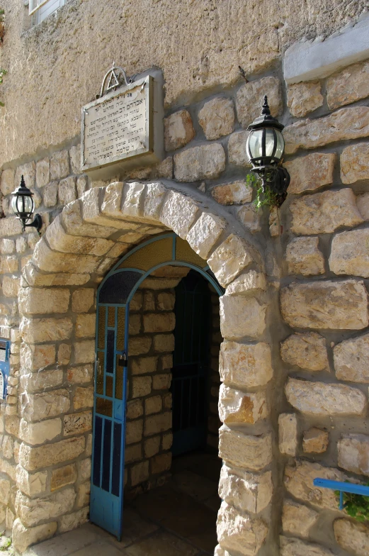 an arched stone wall with a blue door