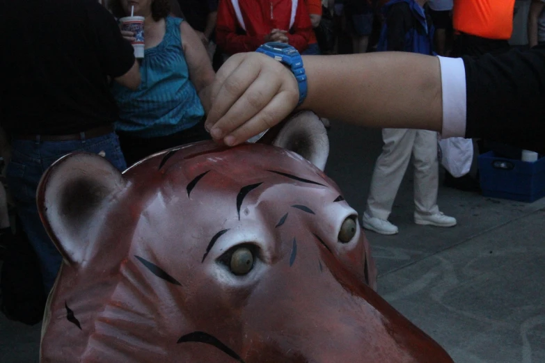 people are surrounding a person painting a cow