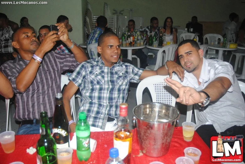 some young men are at a table with drinks and plates