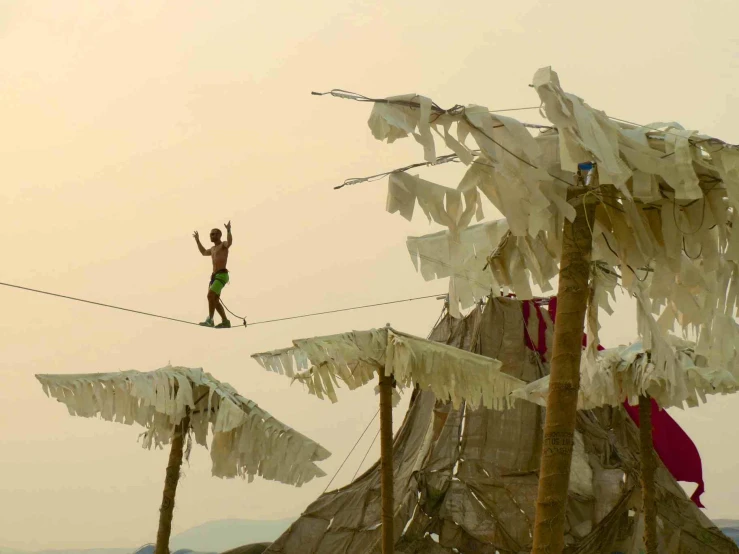 a person is walking across a rope that has been tangled on two poles and is covered with white towels