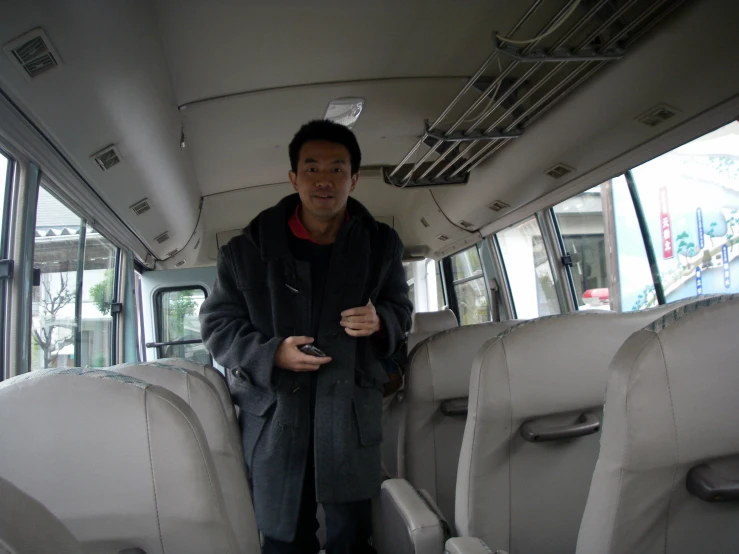 a man standing in the seats in a public transit bus