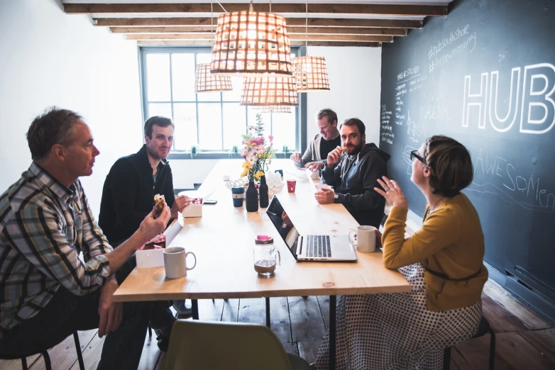 a group of people sitting around a table together