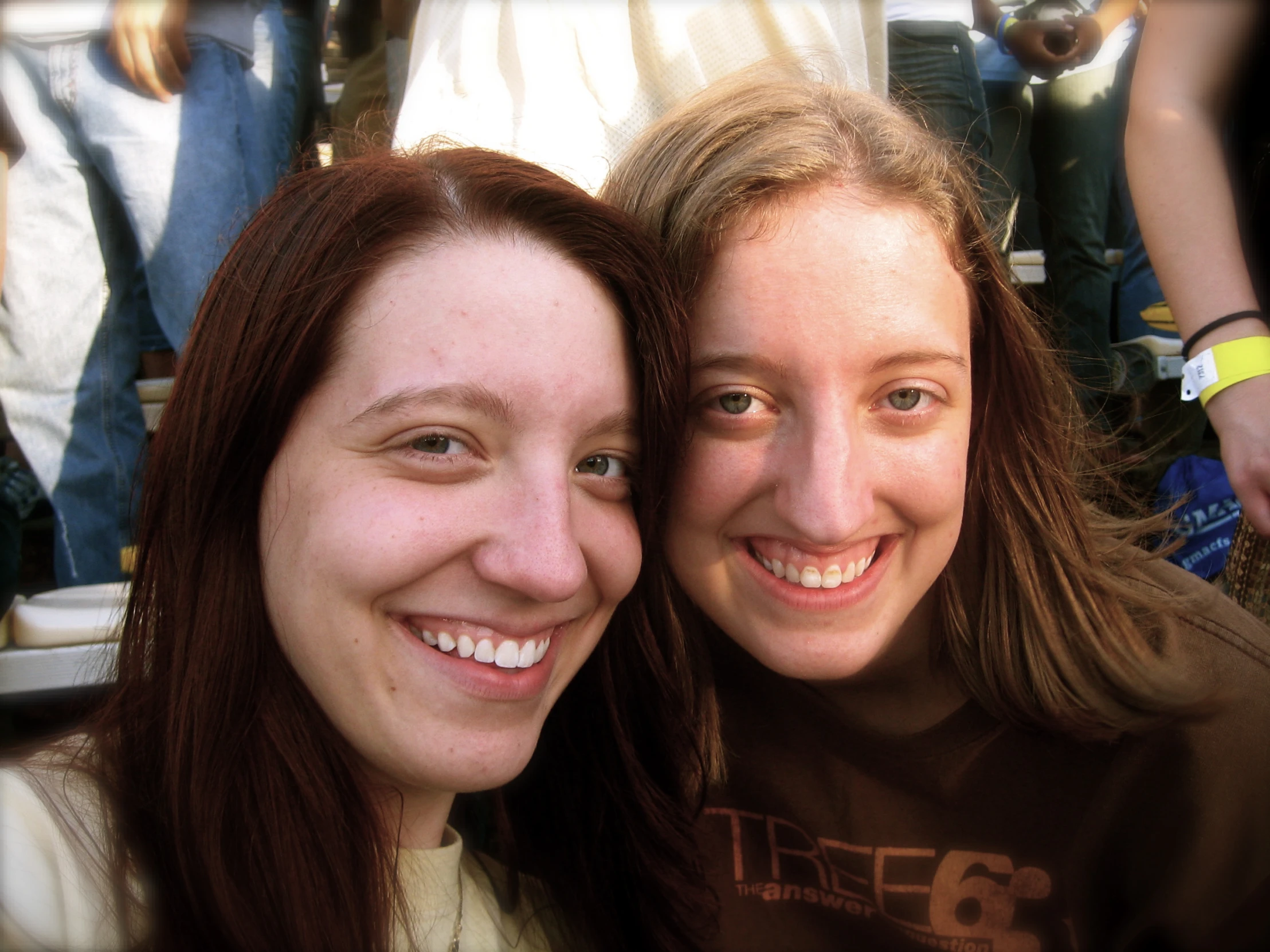 two woman smile brightly with their faces slightly tilted