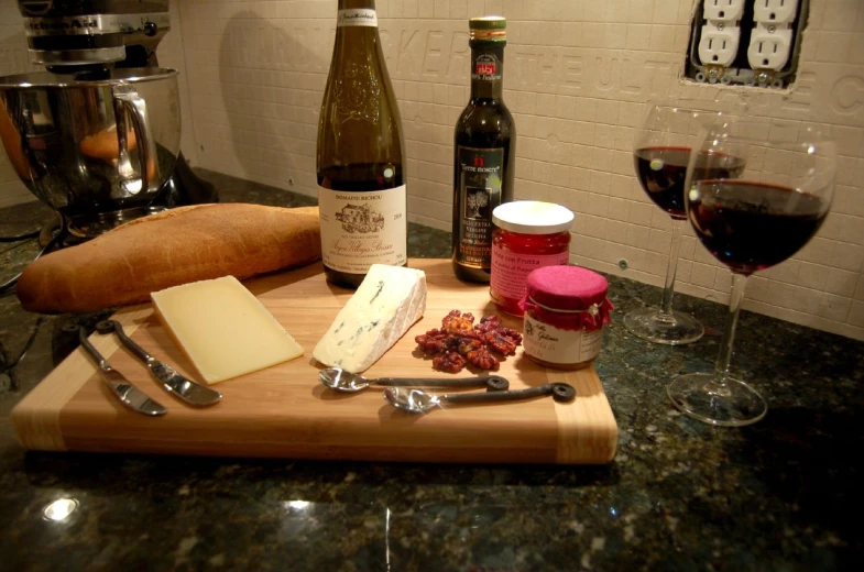 some glasses of wine and cheese on a  board