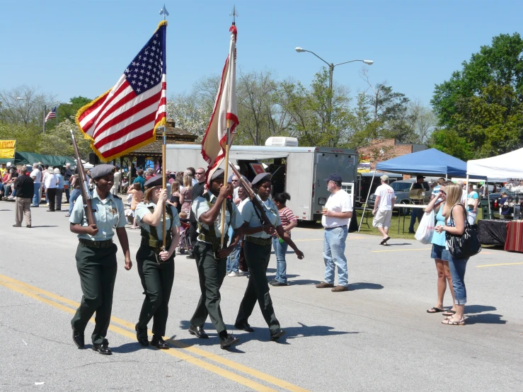 some people are walking and holding american flags