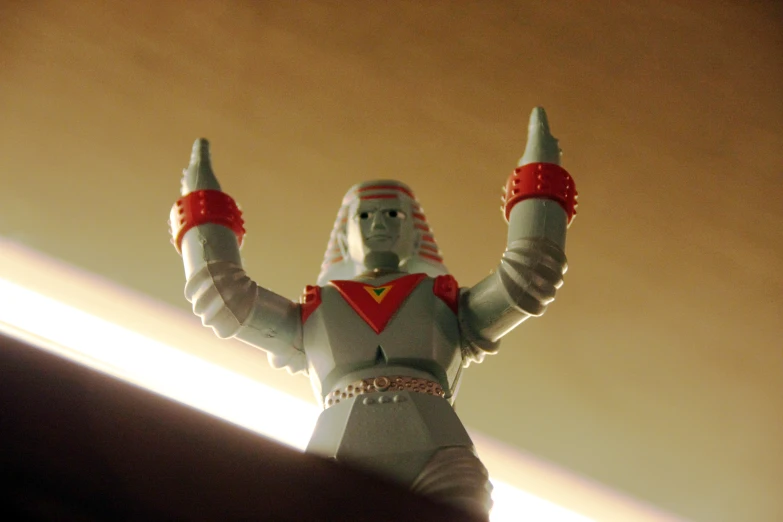 the plastic figurine is wearing several celets and stands on the floor