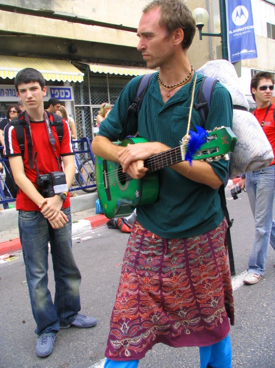 a man with a green guitar in his hands