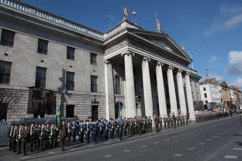 a group of soldiers standing on the sidewalk outside of a building