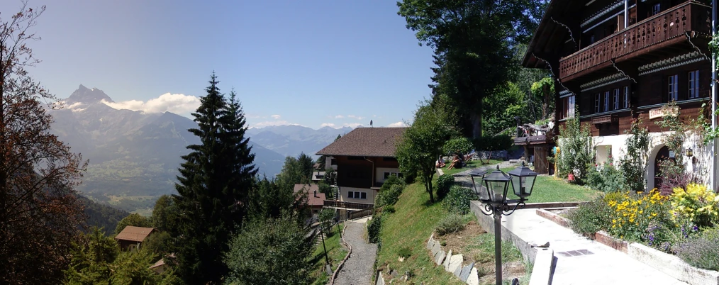 view of some houses, mountains and forest from the path