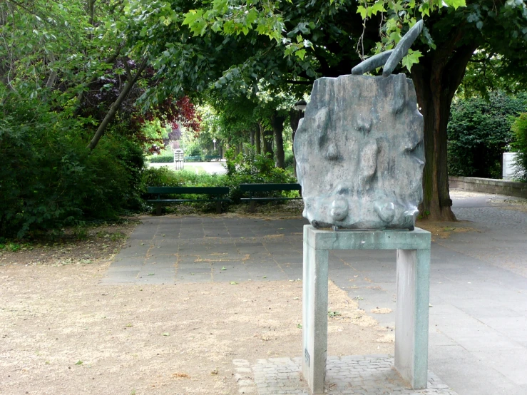 there is a statue on a bench in the park