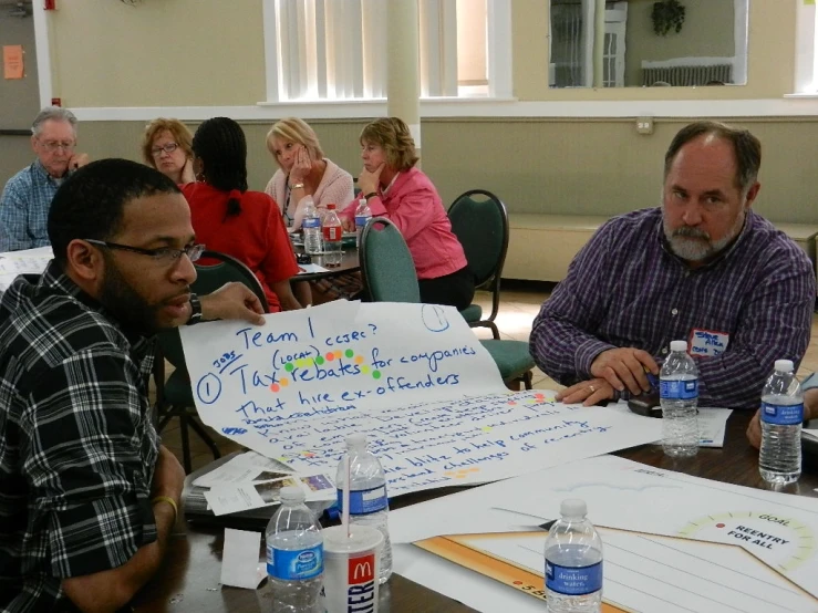 people in a meeting looking at a sign