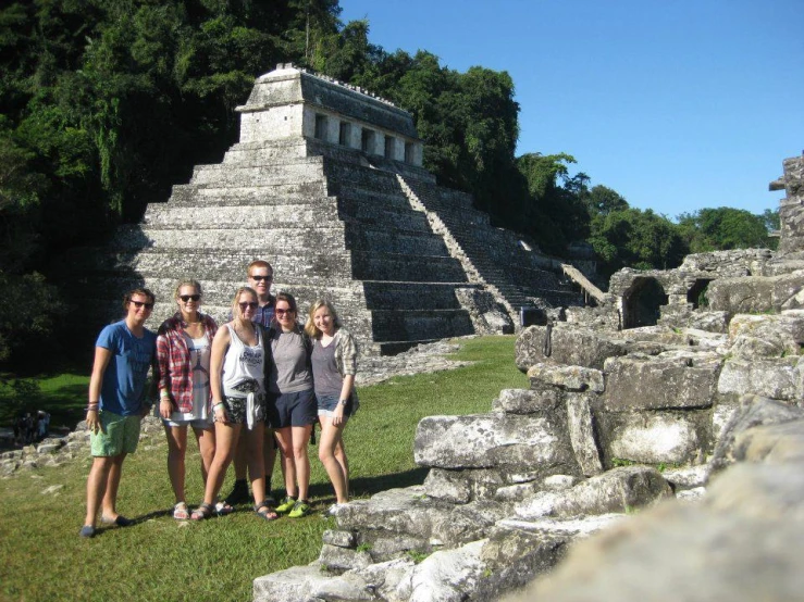 a group of young people standing in front of a building