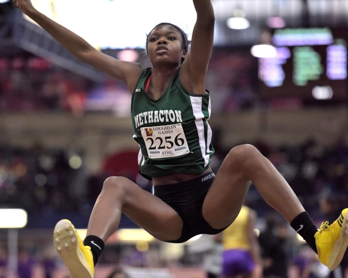 the woman jumps into the air in a competition