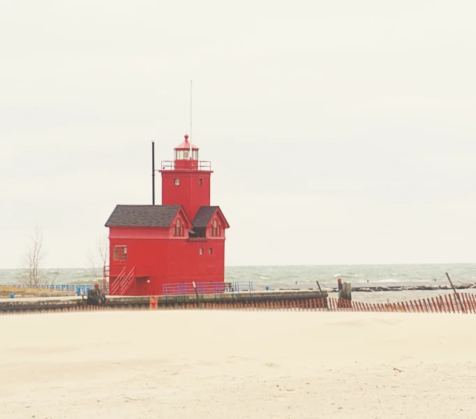 a lighthouse on a sandy area near water