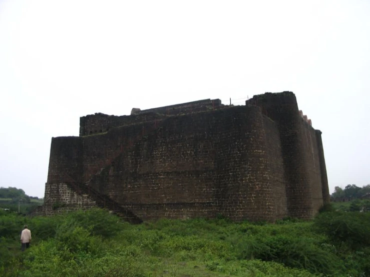 people walking towards an old brick castle in the countryside