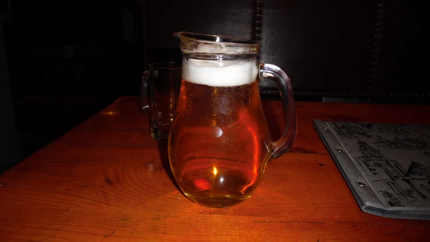 the pitcher is holding an iced beer on a table