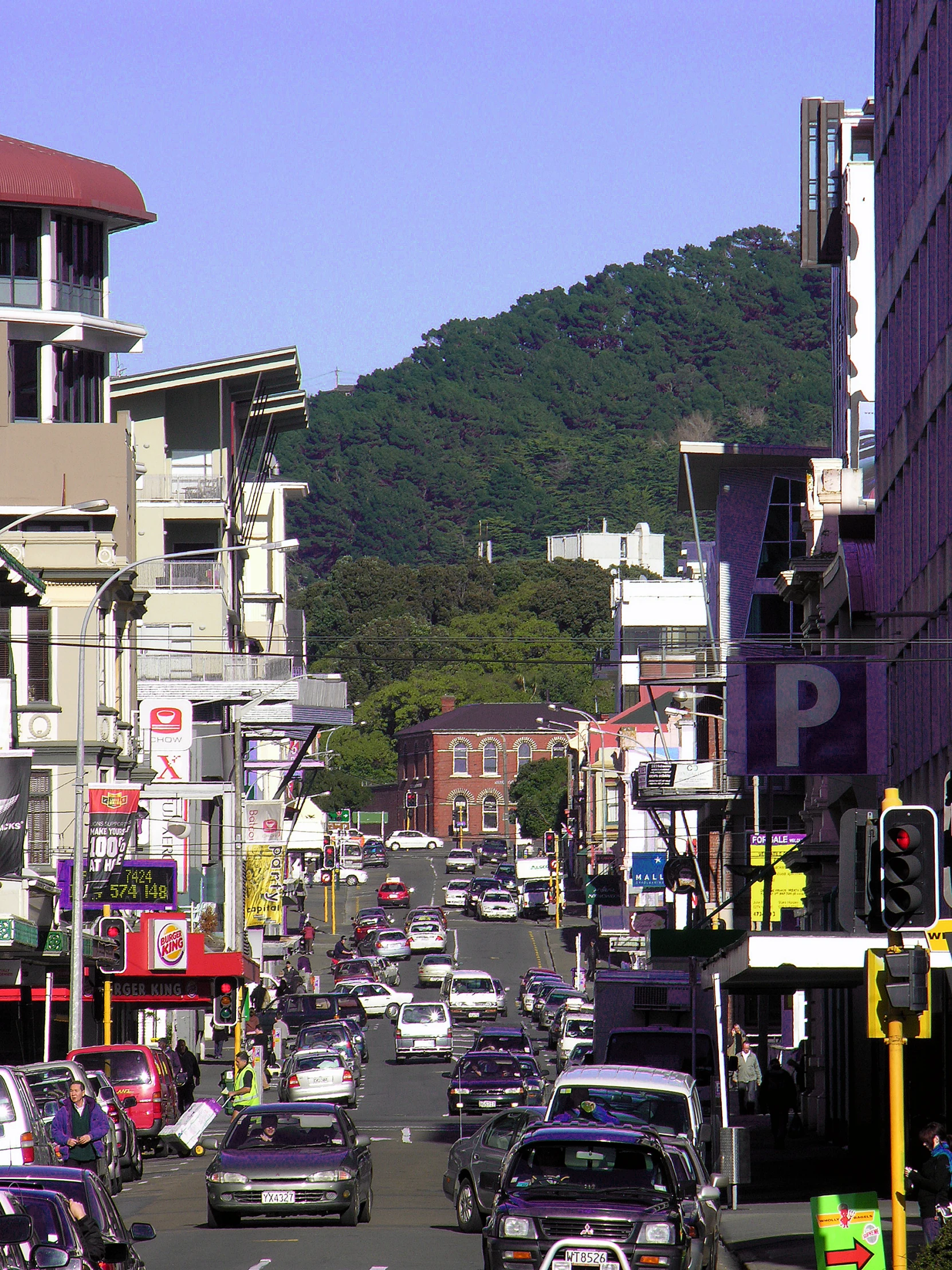 many cars are going down a road in a city