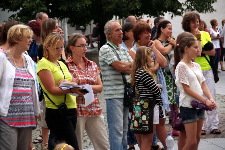 people standing in a group and a man holding a piece of paper