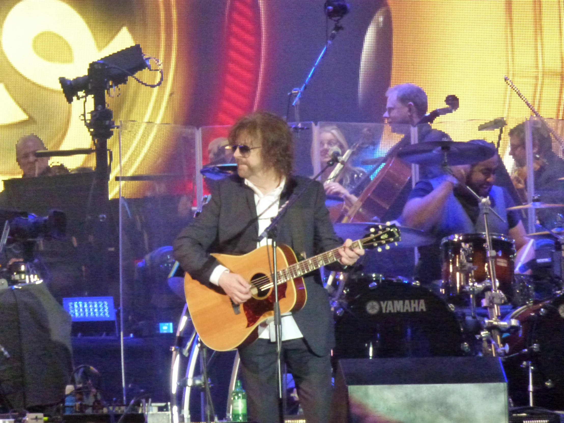 a man with an acoustic guitar on stage