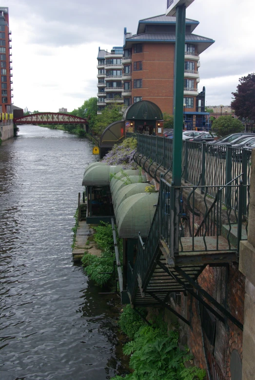 several green long train cars parked on a bridge over a river