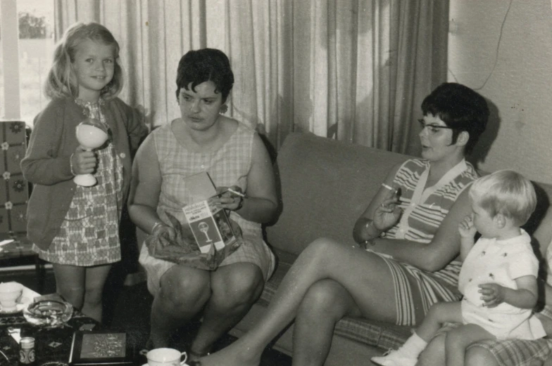 three women and two children sitting on a couch