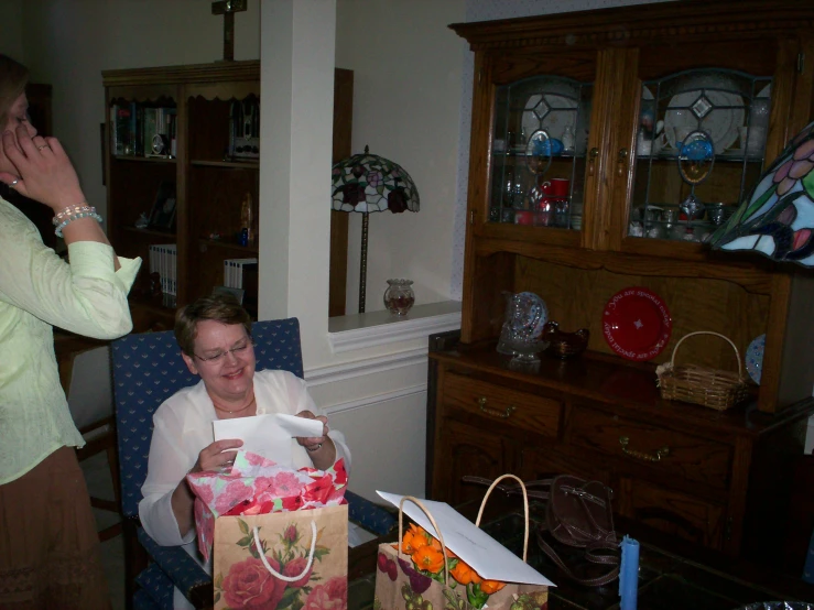 a woman holding an empty shopping bag near other items