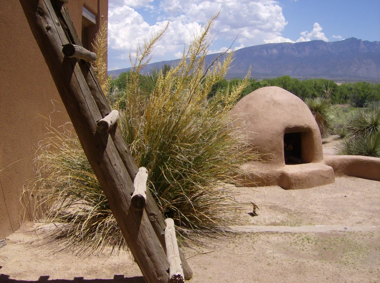 a small hut with a window is near a mountain