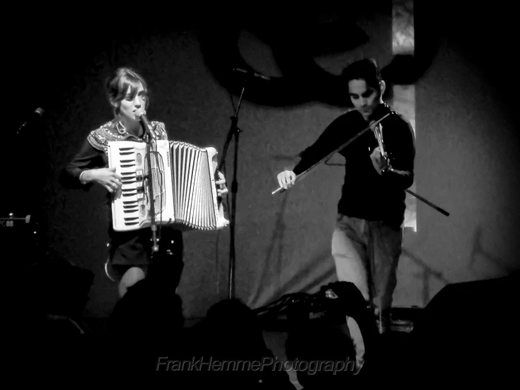 black and white pograph of a musician with a woman playing an accordion