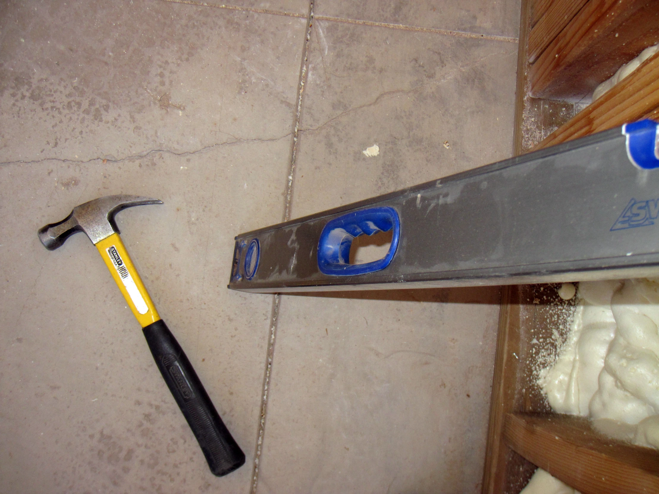 a hammer laying on the ground and a full sized pair of scissors sitting next to it