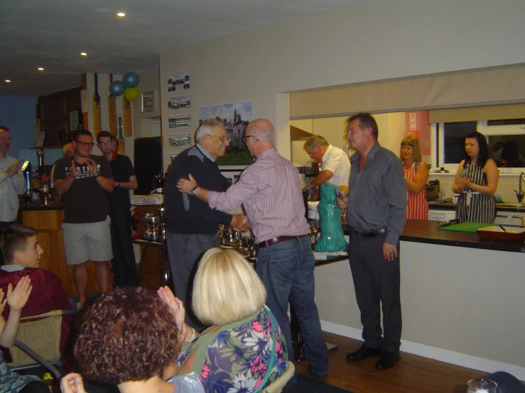 a group of men and women stand in a small room