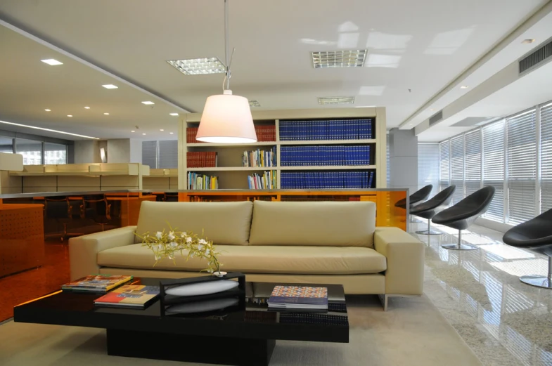 the interior of a room has white furniture and bookshelves