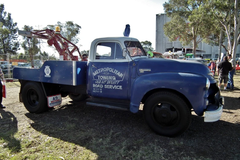 an old blue pickup truck with writing on the side