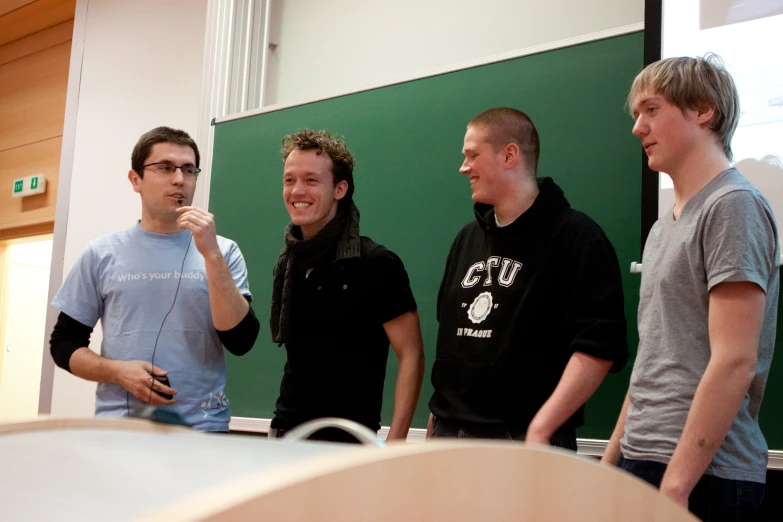 five young men standing next to each other near a sign