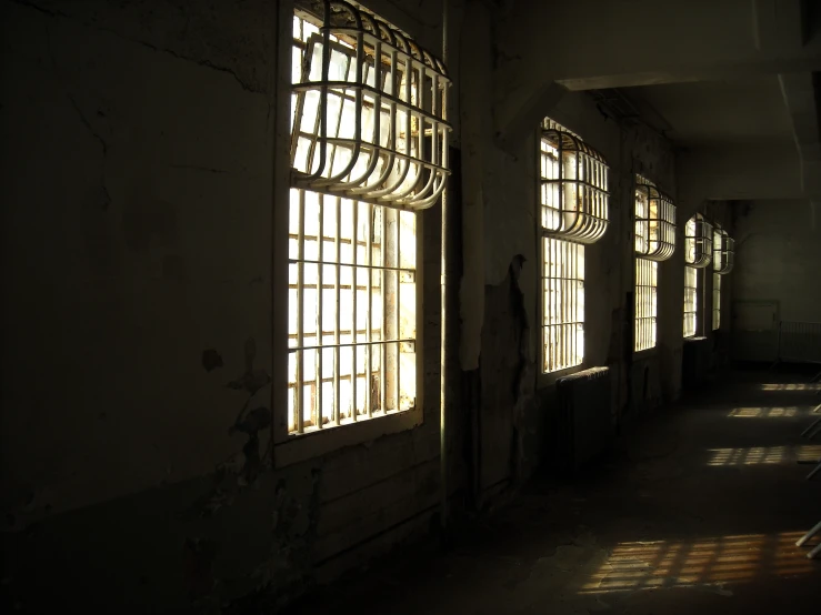 light shining through three windows onto an empty hallway