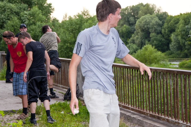 young men playing with a disc near a walkway