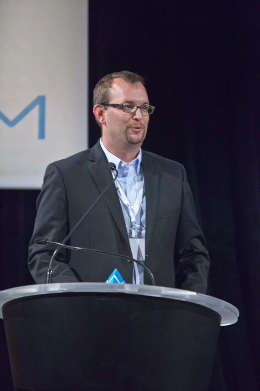 a man standing in front of a microphone speaking into it