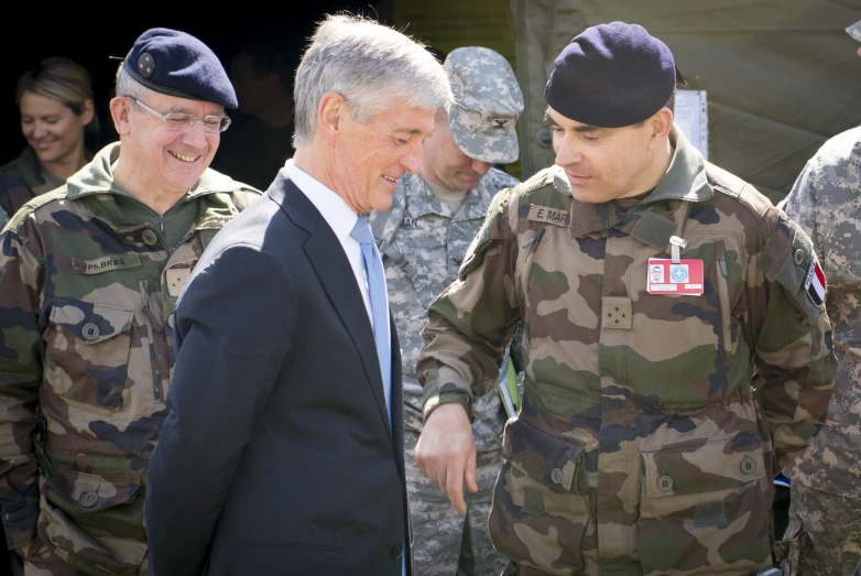 man in uniform smiling while walking with men in uniform
